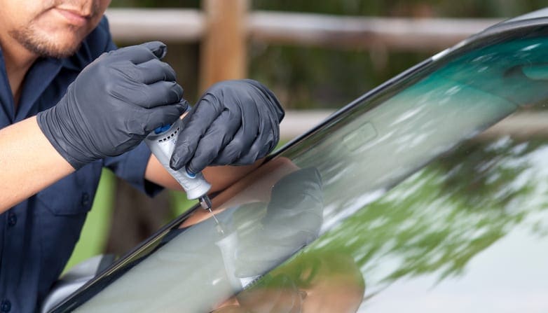 Man repairing and replacing the glass on a car.